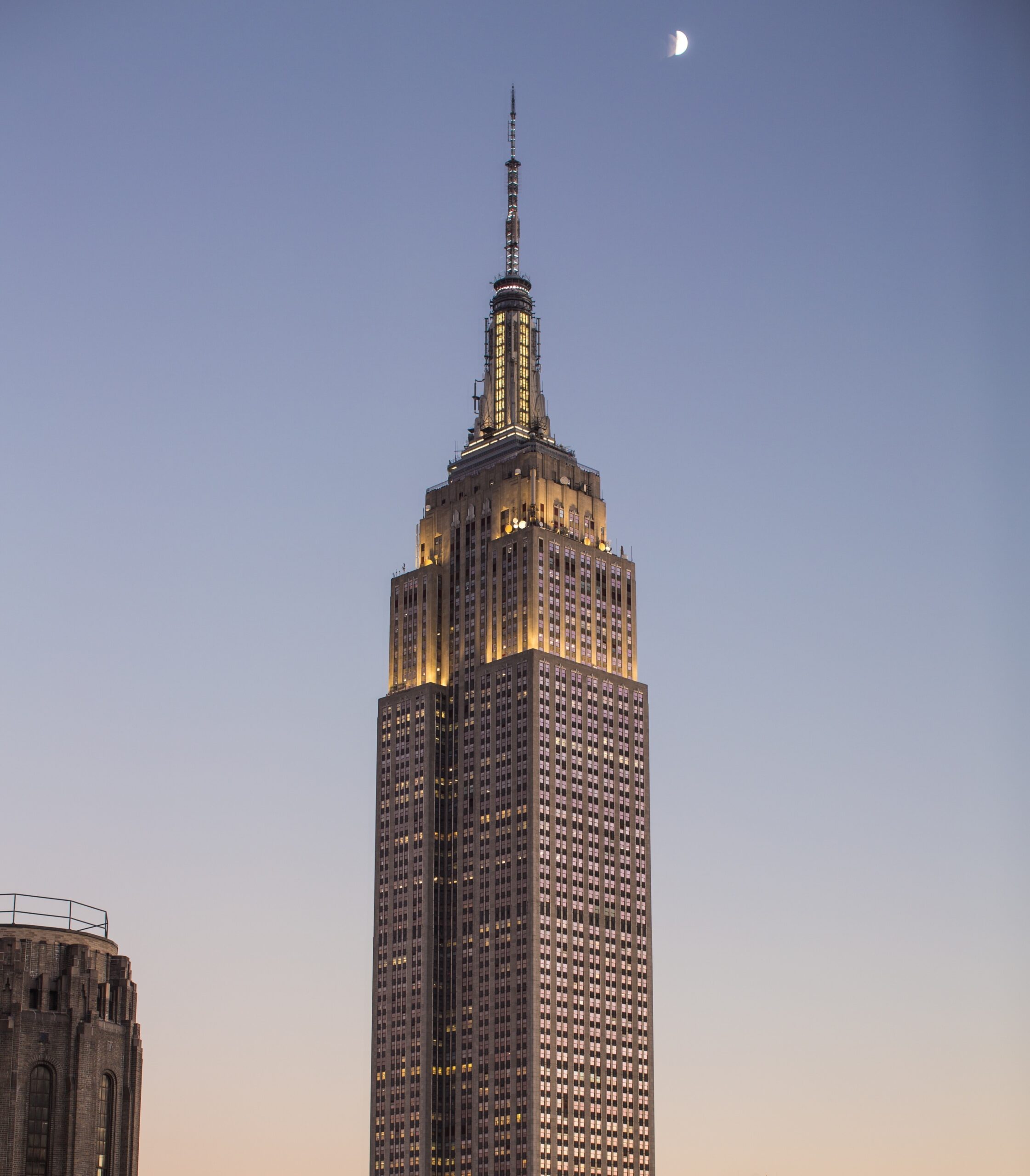An image of the Empire State building in New York against a blue and pink sky at sunset
