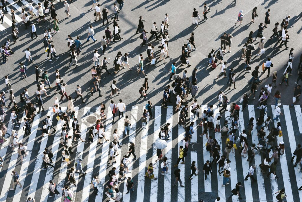 A photograph of a crowd of people on a pedestrian crossing.