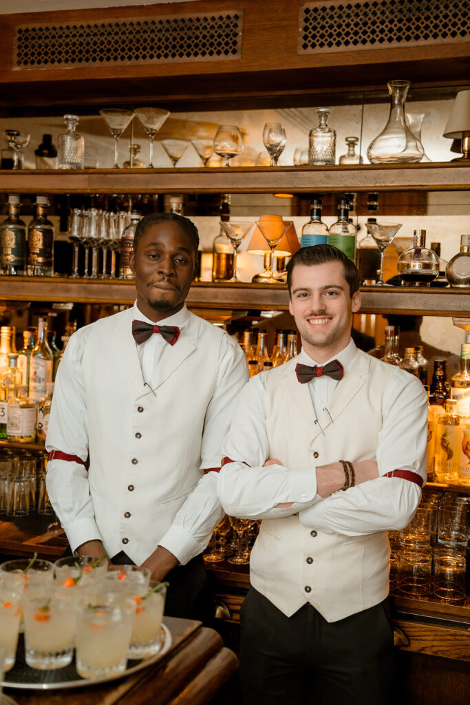 A photograph of two barmen behind a bar.