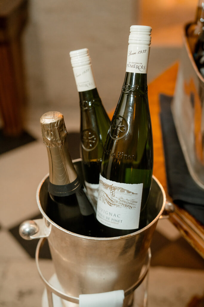 A photograph of three bottles of wine in an ice bucket.