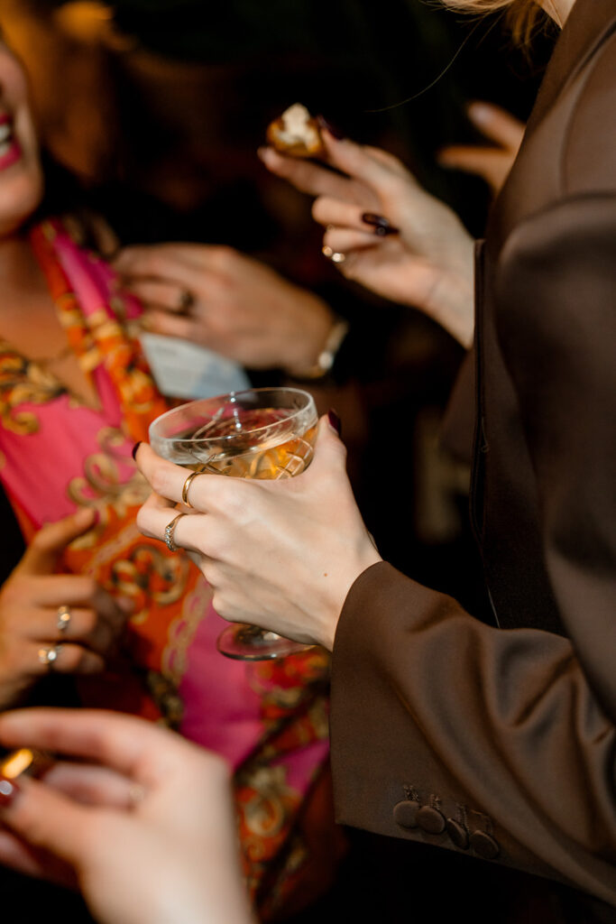 A close-up shot of a women holding a drink and a dessert.
