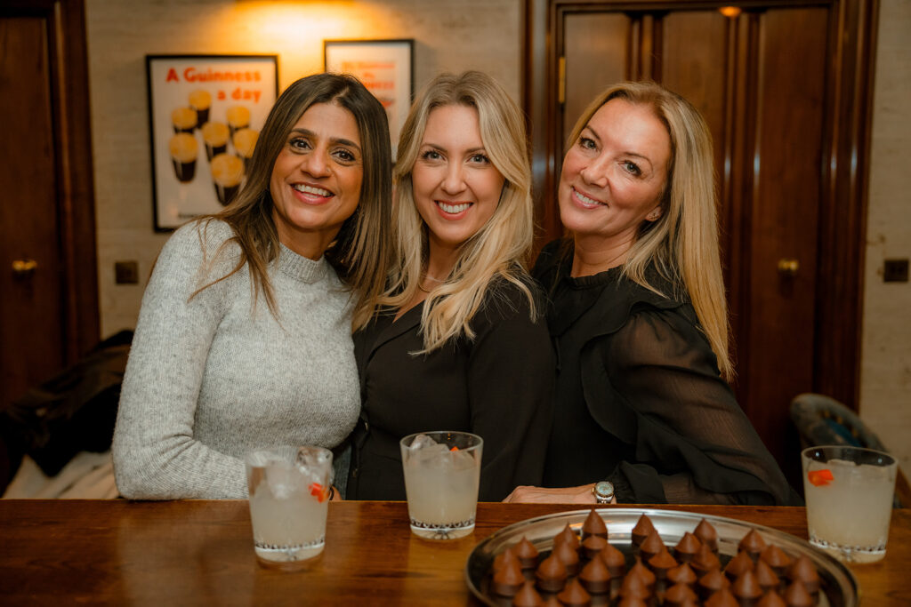 A photograph of threee women smiling,