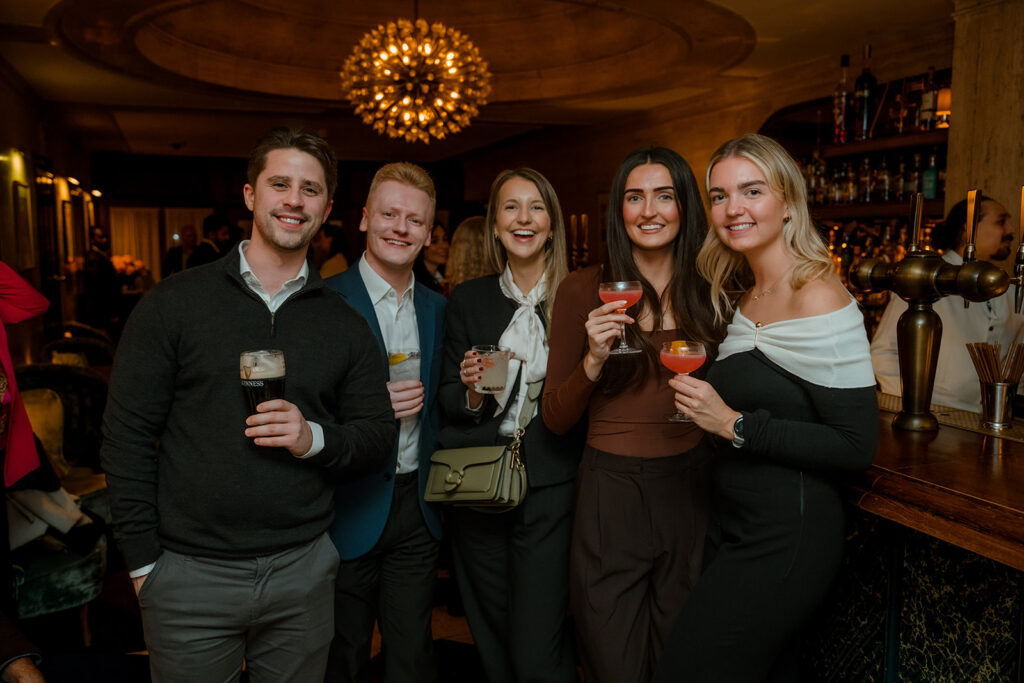A photograph of five people smiling.