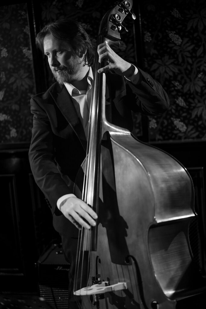 A photograph of a man playing the double bass.
