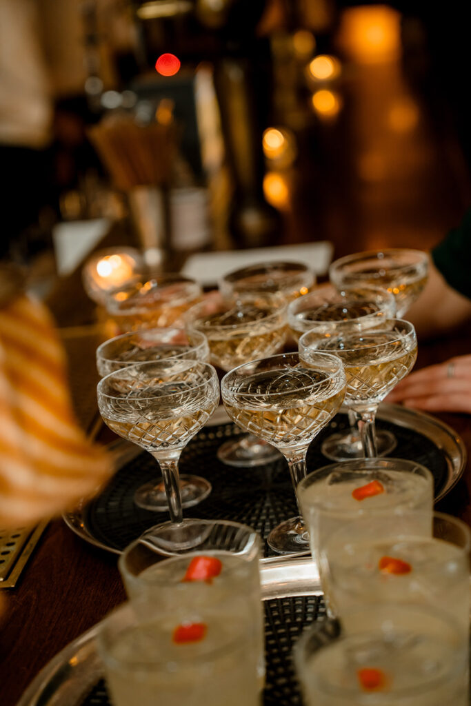 A photograph of several drinks on a bar top.