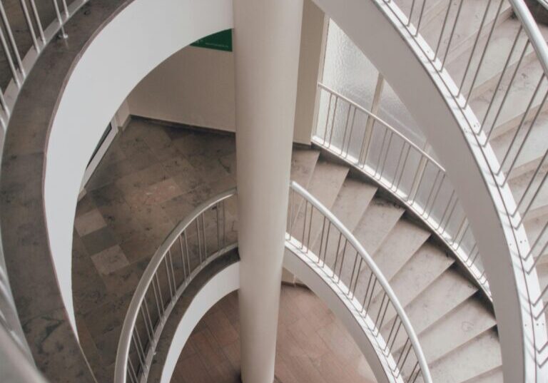 a white spiral staircase with a pole in the middle